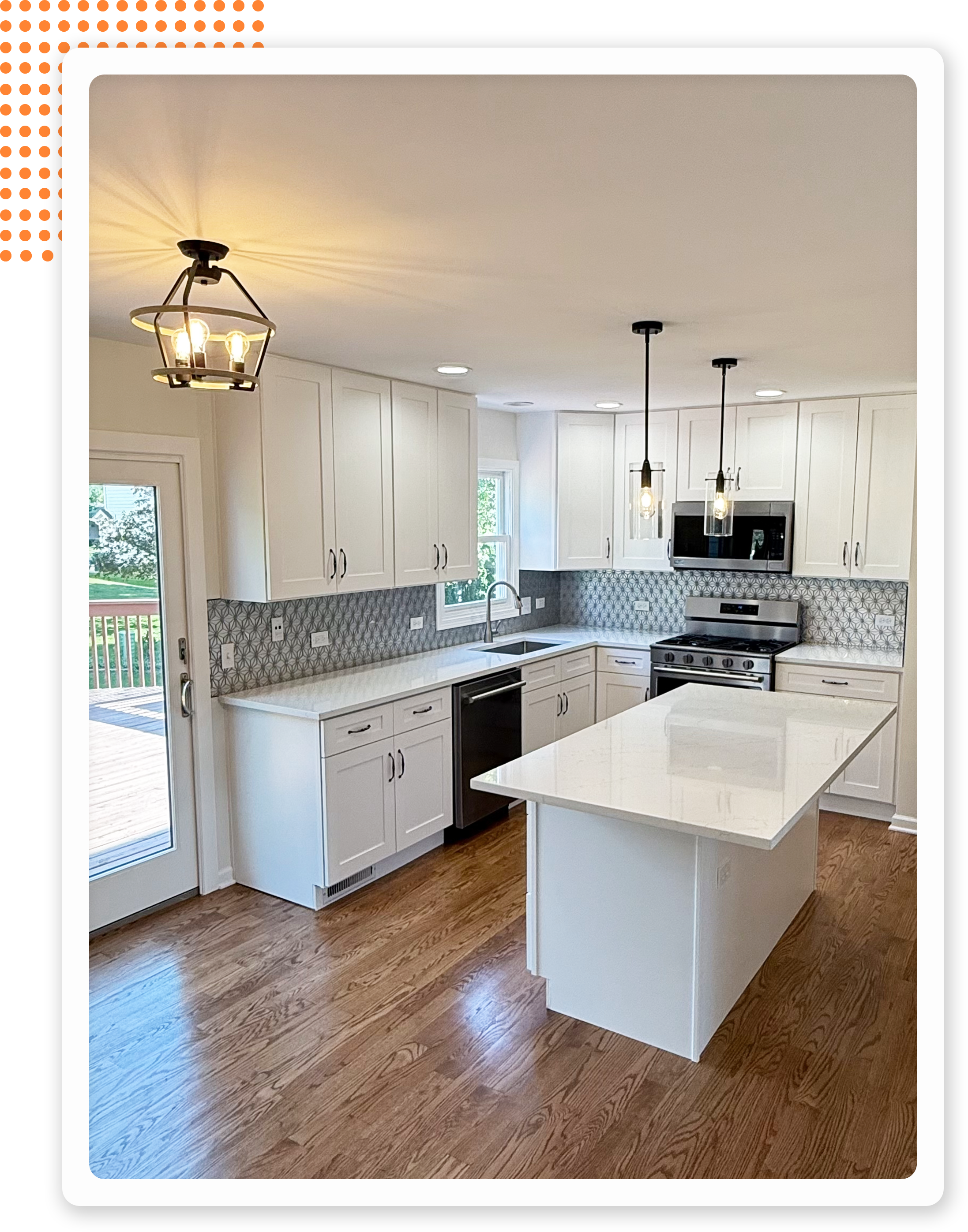 Modern kitchen featuring white cabinets, stainless steel appliances, and a large island with a quartz countertop.